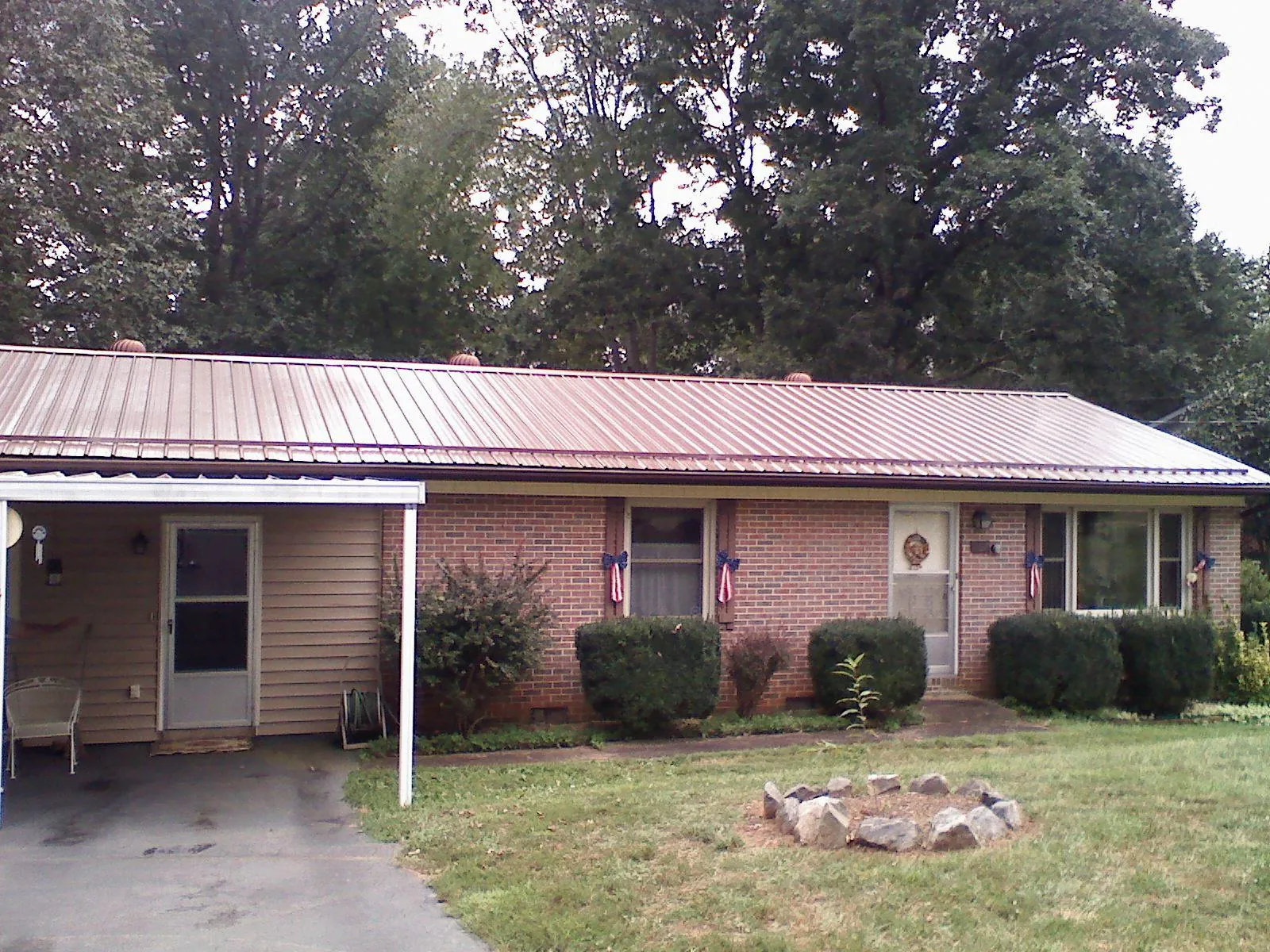 Bronze metal roof and carport on a brick ranch home — Roof Repair work by our crew in Rogersville